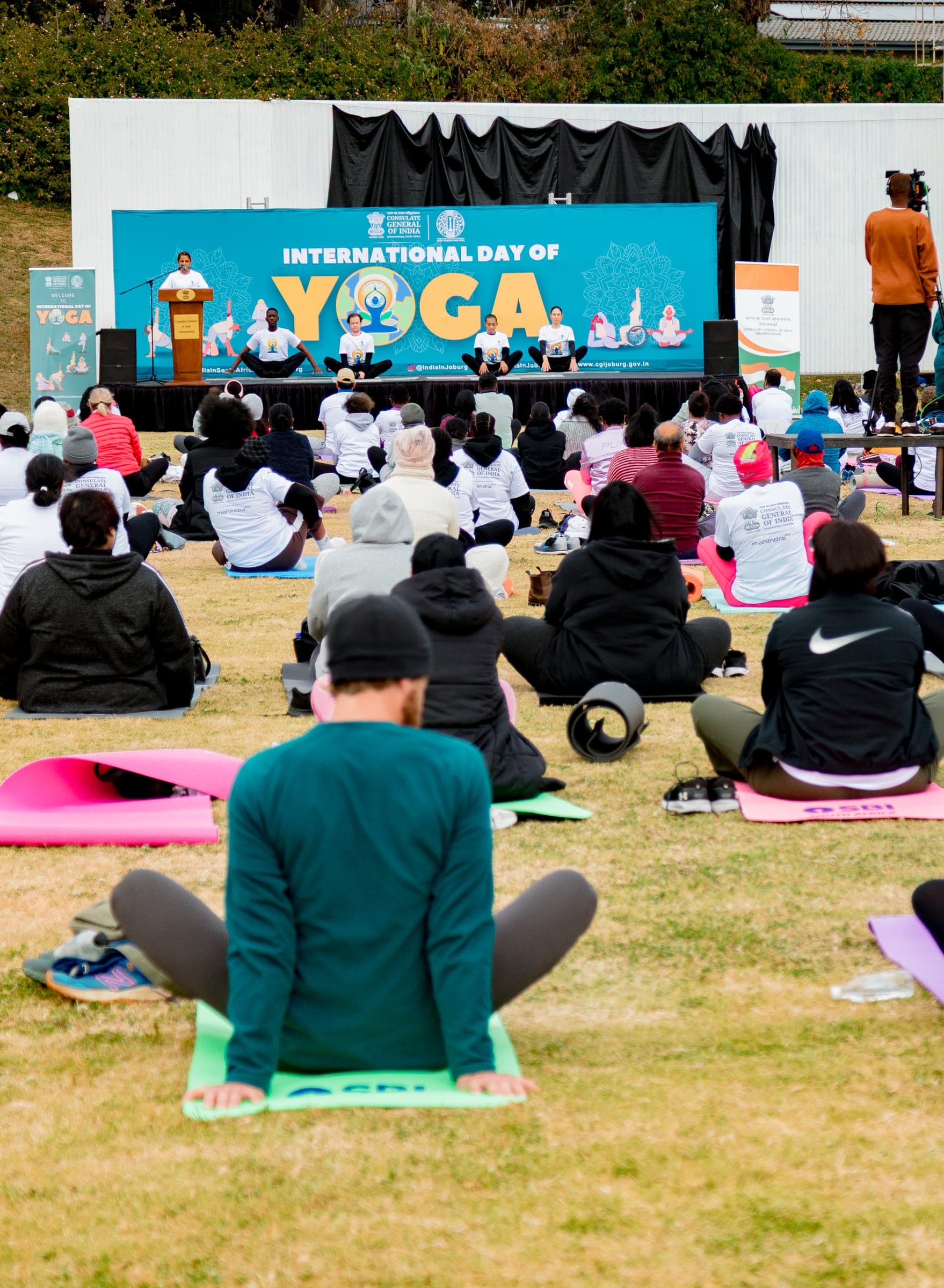 Crowd seated on yoga mats facing the International Yoga Day stage